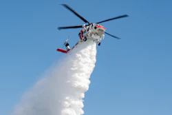 A Firehawk aircraft operated by CAL FIRE demonstrates the powerful concentration of water released from its 1,000 gallon tank for effective wildfire fighting.