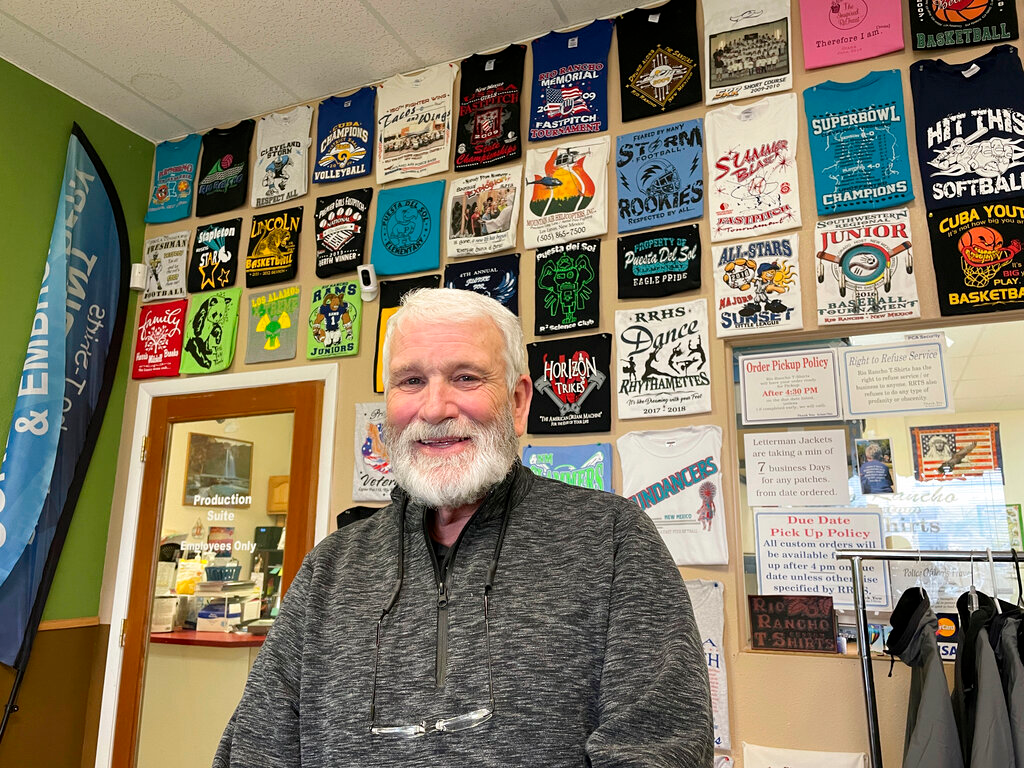 Wayne Holly, the owner of Rio Rancho T-Shirts, poses for a portrait at the family-owned shop in Rio Rancho, N.M., Monday, March 21, 2022. Holly said the small business he and his wife have operated for more than 20 years is feeling the pinch of inflation and that tax rebates offered by state governments won't be enough to combat rising prices or ongoing economic fallout from the coronavirus pandemic.