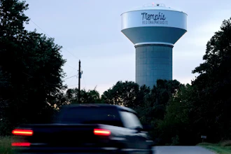A truck drives down a rural road near a water tower marking the location of the Memphis Regional Megasite, Sept. 24, 2021, Stanton, Tenn.
