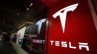 A sign bearing the company logo outside a Tesla store in Cherry Creek Mall in Denver, Feb. 9, 2019. Tesla is recalling nearly nearly 595,000 vehicles in the U.S., Thursday, April 14, 2022, most for a second time, because a “Boombox” function can play sounds over an external speaker and obscure audible warnings for pedestrians.