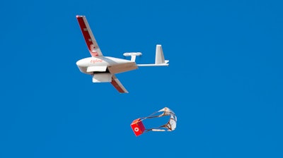 In this photo provided by Zipline, a drone makes a package drop during a demonstration at Zipline's Northern California hub in 2021. Zipline, an American company that specializes in using autonomously flying drones to deliver medical supplies, has taken off in Japan.
