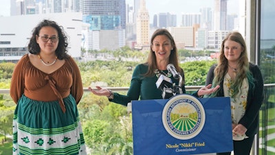 Florida Commissioner of Agriculture and Consumer Services Nikki Fried, center, speaks during a news conference along with youth climate leaders, Valholly Frank, left, and Delaney Reynolds, right, Thursday, April 21, 2022, at the Phillip & Patricia Frost Museum of Science in Miami. Fried unveil a proposed rule to require that utilities operating in the state generate 100% of their electricity from renewable sources of energy by 2050.