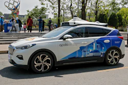 A Baidu Apollo Robotaxi passes its customer service counter setup at the Shougang Park in Beijing, Sunday, May 2, 2021. China has granted Chinese internet services company Baidu and a rival autonomous car company, Pony.ai, permits to provide driverless ride-hailing services to the public in Beijing, a significant regulatory step in the country's pursuit of driverless technology.
