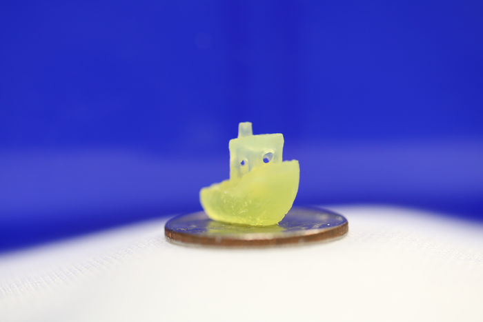 A boat figurine produced by a new 3D printing process that makes it possible to print an object within a volume of resin &ndash;like an action figure floating in the center of a block of Jell-O&ndash;rather than having to build the object layer by layer.