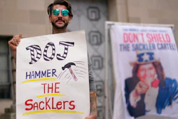 Nicholas Rivers of Maine, holds a sign that reads DOJ Hammer the Sacklers' during a protest with advocates for opioid victims outside the Department of Justice, Friday, Dec. 3, 2021, in Washington. A federal appeals panel is scheduled to hear arguments on whether members of the Sackler family can be granted protection from lawsuits as part of a bankruptcy settlement for the company they own, OxyContin maker Purdue Pharma. If the company doesn’t get what it wants, it could have to fight off thousands of individual lawsuits.