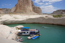 In this July 30, 2021, photo, a houseboat rests in a cove at Lake Powell near Page, Ariz. Federal water officials have announced that they will keep hundreds of billions of gallons of Colorado River water inside Lake Powell instead of letting it flow downstream to southwestern states and Mexico. U.S. Assistant Secretary of Water and Science Tanya Trujillo said Tuesday, May 3, 2022, that the move would allow the Glen Canyon Dam to continue producing hydropower while officials strategize how to operate the dam with a lower water elevation.