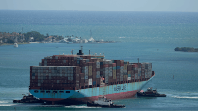 Three tugboats work together to rotate the Axel Maersk container ship as it arrives into port, on Oct. 21, 2021, in Miami.