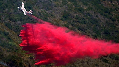 A plane drops fire retardant onto the Coastal Fire Thursday, May 12, 2022, in Laguna Niguel, Calif.