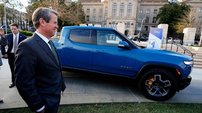 Gov. Brian Kemp stands next to a Rivian electric truck while announcing the company's plans to build a $5 billion plant east of Atlanta projected to employ 7,500 workers, Thursday, Dec. 16, 2021, in Atlanta. Georgia officials could announce a second massive electric vehicle plant to be built by Hyundai near Savannah in coming days.
