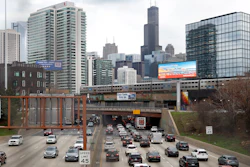 Traffic flows along Interstate 90 highway as a Metra suburban commuter train moves along an elevated track in Chicago on March 31, 2021. With upcoming data showing traffic deaths soaring, the Biden administration is steering $5 billion in federal aid to cities and localities to address the growing crisis by slowing down cars, carving out bike paths and wider sidewalks, and nudging commuters to public transit.