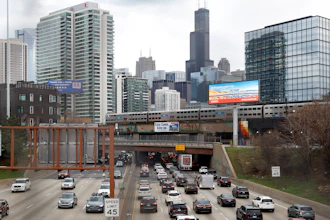 Traffic flows along Interstate 90 highway as a Metra suburban commuter train moves along an elevated track in Chicago on March 31, 2021. With upcoming data showing traffic deaths soaring, the Biden administration is steering $5 billion in federal aid to cities and localities to address the growing crisis by slowing down cars, carving out bike paths and wider sidewalks, and nudging commuters to public transit.