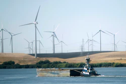 A tugboat pushes a barge down the Sacramento River past wind turbines near Rio Vista, Calif., on Monday, Sept. 23, 2013.