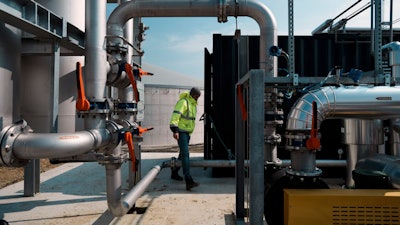 A worker walks among pipelines that will carry gas toward Rambouillet, France, May 3, 2022.