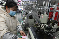 A worker operates a machine in a factory in Funan county, China, March 1, 2022.