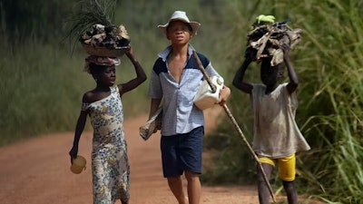 Children living in a cocoa-producing village walk back from the fields on the outskirts of the town of Oume, Ivory Coast, on June 30, 2005.