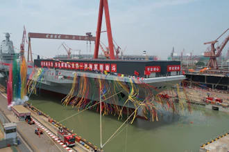 In this photo released by Xinhua News Agency, coloured smoke mark the launch ceremony for China's third aircraft carrier christened Fujian at a dry dock in Shanghai on Friday, June 17, 2022. China on Friday launched its third aircraft carrier, the first such ship to be both designed and built entirely within the country.