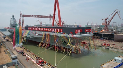 In this photo released by Xinhua News Agency, coloured smoke mark the launch ceremony for China's third aircraft carrier christened Fujian at a dry dock in Shanghai on Friday, June 17, 2022. China on Friday launched its third aircraft carrier, the first such ship to be both designed and built entirely within the country.