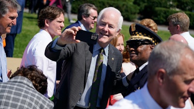 Sen. John Cornyn, R-Texas, takes a selfie as he arrives to an event to celebrate the passage of the 'Bipartisan Safer Communities Act,' a law meant to reduce gun violence, on the South Lawn of the White House, Monday, July 11, 2022, in Washington.