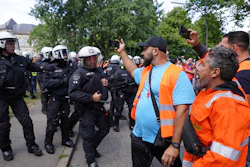 Police officers are pushed back by demonstrators after the arrest of a participant in a demonstration by port workers, Hamburg, Germany, July 15, 2022.