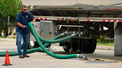 A gas tank driver adjusts his hose hookup to an underground tank on May 24, 2022, in Jackson, Miss. High diesel prices are driving up the cost of most goods, from groceries to Amazon orders and furniture, as nearly everything that is delivered, whether by truck, rail or ship, uses diesel fuel. Truckers are turning down hauling jobs in the states with the most expensive diesel.