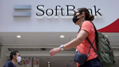 People walk by a SoftBank shop on Monday, Aug. 8, 2022, in Tokyo. Japanese technology company SoftBank Group sank into losses for the first fiscal quarter as the value of its investments declined amid global worries about inflation and interest rates.