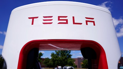 Tesla Supercharger is seen at Willow Festival shopping plaza parking lot Wednesday, Aug. 10, 2022, in Northbrook, Ill. Tesla is splitting its stock 3 for 1, so after the close of trading Tuesday, Aug. 23, investors will receive two additional Tesla shares for every one they owned as of Aug. 17. In theory, that should drop Tesla’s share price by about two-thirds before trading starts on Wednesday.
