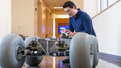 Cagri Kilic, postdoctoral research fellow in the WVU Statler College of Engineering and Mineral Resources, shows off a rover that he developed to research slips in planetary rovers. Two other researchers are applying this same technology to improve safety in retail and wholesale settings.