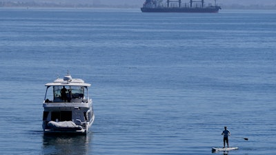 A person paddle boards near a boat in McCovey Cove in San Francisco, Sunday, Sept. 4, 2022.