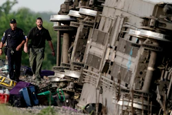 Law enforcement personnel inspect the scene of an Amtrak train that derailed after striking a dump truck near Mendon, Mo., June 27, 2022.