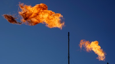 Flares burn off methane and other hydrocarbons at an oil and gas facility in Lenorah, Texas, Friday, Oct. 15, 2021.