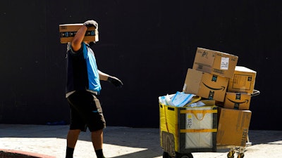 An Amazon worker delivers boxes in Los Angeles on Oct. 1, 2020. Amazon said Wednesday, Sept. 28, 2022, that it is raising its average starting pay for frontline workers from $18 to $19 a hour, a boost that could help it attract more employees in a tight labor market as the holiday season approaches.