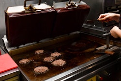 A worker cooks burgers at Zing Burger store in Budapest, Hungary, Monday, Sept. 12, 2022. Richard Kovacs, a business development manager for the Hungarian burger chain, said some of the chain's 15 stores have seen a 750% increase in electricity bills since the beginning of the year – leading to additional monthly costs of up to 1.5 million Hungarian forints ($3,840) per store.