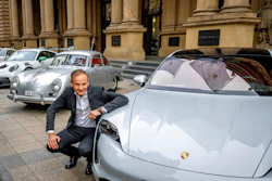 CEO of Porsche car maker Oliver Blume kneels next to Porsche cars at the start of Porsche's market listing at the stock market in Frankfurt, Germany, Thursday, Sept. 29, 2022.