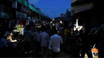 People come out of their homes during a power failure in Dhaka, Bangladesh Tuesday Oct. 4, 2022.