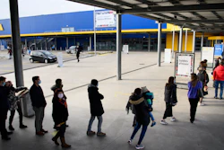 People wearing protective face mask line up in a queue outside the Swedish furniture giant Ikea shop the last day of the opening of non-essential shops during the coronavirus disease (COVID-19) outbreak, in Aubonne, Switzerland, Saturday, January 16, 2021.