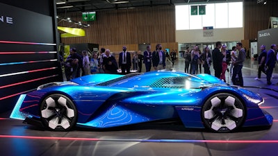 Visitors watch the Renault Apine H2 hydrogen-powered concept supercar at the Paris Car Show Monday, Oct. 17, 2022 in Paris.