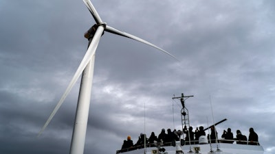Guests tour one of the turbines of America's first offshore wind farm, owned by the Danish company, Orsted, off the coast of Block Island, R.I., as part of a wind power conference, Oct. 17, 2022.