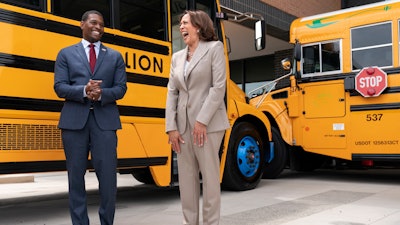 Vice President Kamala Harris, right, laughs with Environmental Protection Agency Administrator Michael Regan, during a tour of electric school buses at Meridian High School in Falls Church, Va., May 20, 2022.
