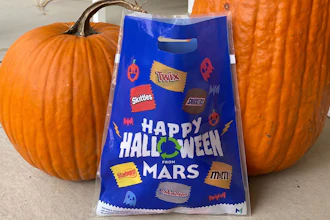 A bag distributed by Mars - the maker of Snickers and M&M's - for recycling candy wrappers is positioned between pumpkins in Ann Arbor, Mich., on October 19, 2022.