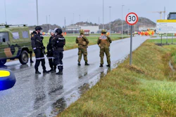 Police and personnel from the Home Guard stand guard outside the land plant of the Ormen Lange gas field after a person called in a bomb threat against the plant, in Aukra, Norway, Thursday Oct. 13, 2022.