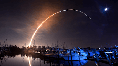 NASA's new moon rocket lifts off from the Kennedy Space Center in Cape Canaveral, Wednesday morning, Nov. 16, 2022, as seen from Harbor town Marina on Merritt Island, Fla. The moon is visible in the sky.