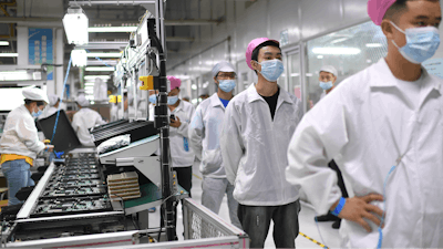 Workers line up to get tested for COVID-19 at the Foxconn factory in Wuhan in central China's Hubei province on Aug. 5, 2021.