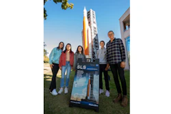 Student employees in the Industry Design Experience for Auburn Students, or IDEAS, program stand by a blow-up replica of the Space Launch System they are working on.