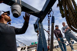 Mark Hager, left, positions a camera with the help of Anthony Lucia, right, as captain Al Cottone watches the feed on a monitor from his boat, the Sabrina Maria, Gloucester, Mass., May 11, 2022.