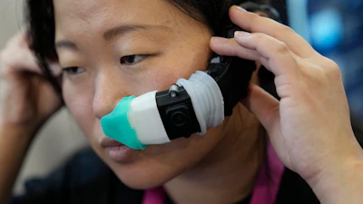 An exhibitor displays the OVR Technology ION 3 stand-alone wearable at the OVR Technology booth during the CES tech show Thursday, Jan. 5, 2023, in Las Vegas. The ION 3 is a wearable device that delivers scents using cartridges, and the delivery system is synchronized with the content users are viewing in VR, AR, and mobile or desktop computing devices.