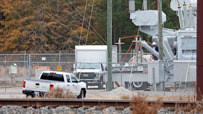 Workers work on equipment at the West End Substation, at 6910 NC Hwy 211 in West End, N.C., Monday, Dec. 5, 2022, where a serious attack on critical infrastructure has caused a power outage to many around Southern Pines, N.C.