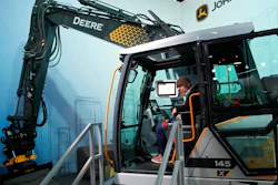 People look at a John Deere electric excavator at the John Deere booth during the CES tech show Friday, Jan. 6, 2023, in Las Vegas.