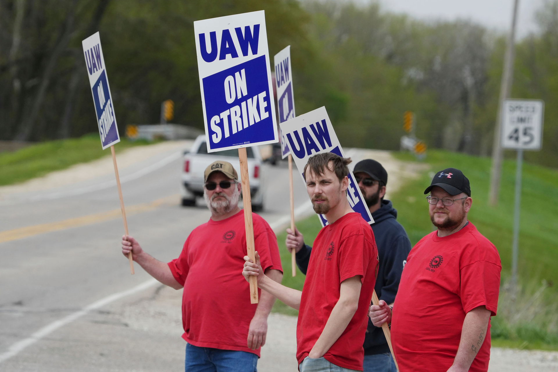 Members of United Auto Workers Local 807 carry picket signs after going on strike, May 2, 2022, at a CNH plant in Burlington, Iowa.