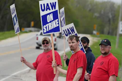 Members of United Auto Workers Local 807 carry picket signs after going on strike, May 2, 2022, at a CNH plant in Burlington, Iowa.