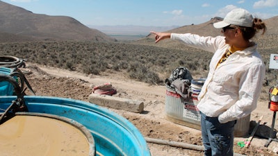 In this Sept. 13, 2018, file photo, Melissa Boerst, a Lithium Nevada Corp. geologist, points to an area of future exploration from a drill site at the Thacker Pass Project in Humboldt County, Nev.